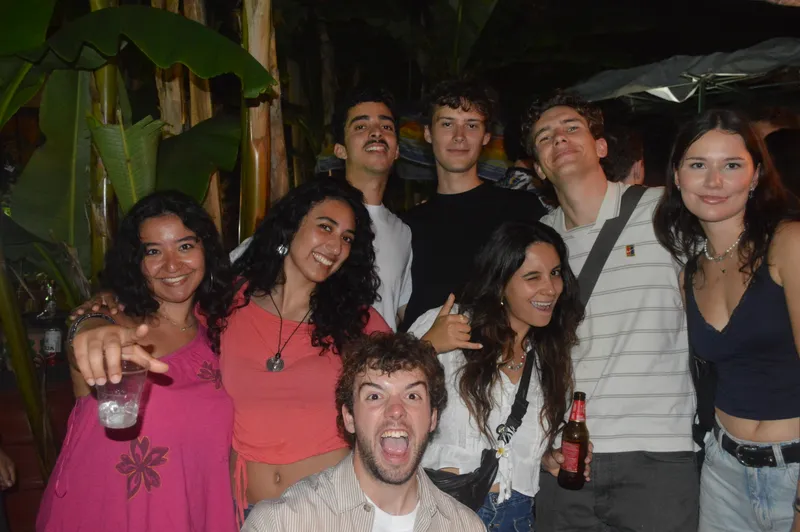 A group of people smiling and posing for a photo together at night.